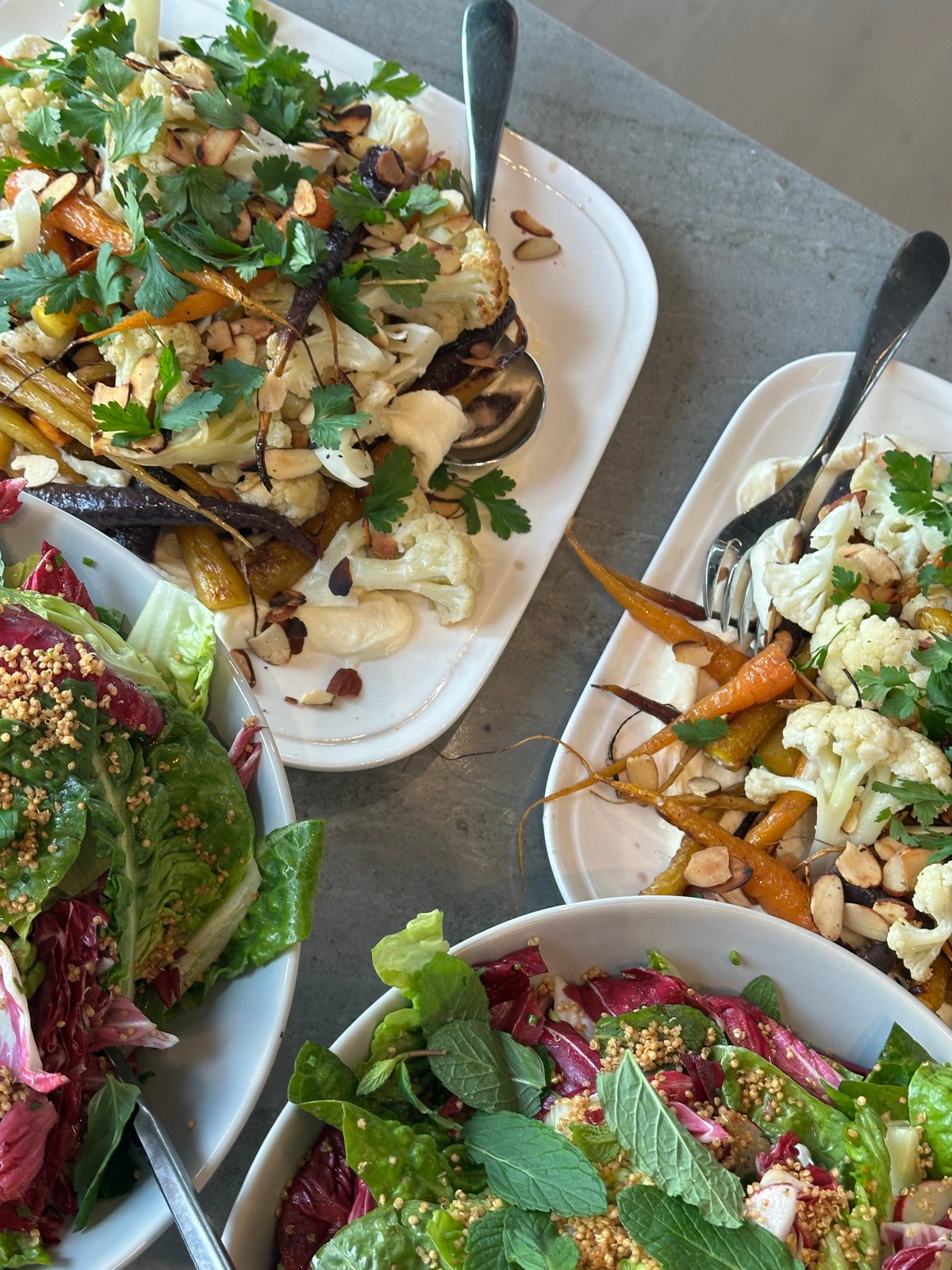 Shared table spread of roasted vegetables and seasonal salads by Artisan at Home